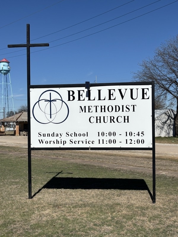 Bellevue Methodist Church sign with service times and Bellevue water tower